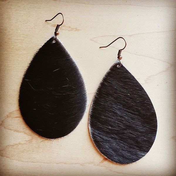 Leather teardrop earrings in dark hair on hide